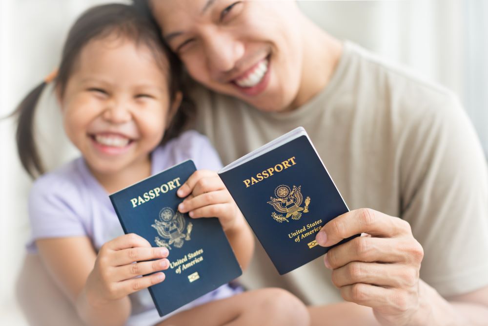 father and daughter smiling and holding USA passports